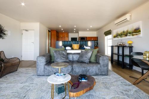 a living room with a couch and a table at Beach Villa Wilderness in Wilderness