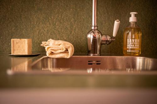 - un évier de cuisine avec une serviette et une bouteille d'alcool dans l'établissement Superbe appartement au cœur du Panier - Vieux-Port, à Marseille