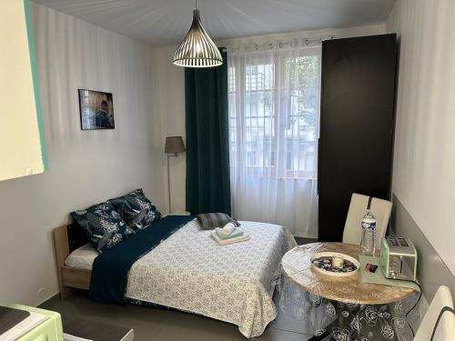 une petite chambre avec un lit et une table dans l'établissement Studio ElevenStar, à Aubervilliers
