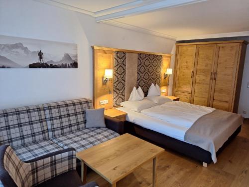 a hotel room with a bed and a couch at Hotel Zum Stern - Bergbahnen inklusive im Sommer 2025 in Bad Hofgastein