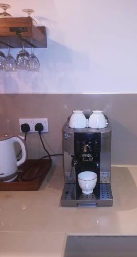a coffee maker with three cups on top of it at Aryan Beach Villa in Wadduwa