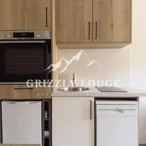 a kitchen with a stove and a dishwasher at Grizzly Lodge - appartement duplex sur les pistes in Les Gets
