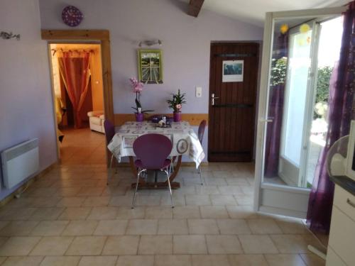 a dining room with a table and purple chairs at Maison Indépendante 3étoiles avec grand jardin in Saint-Germain