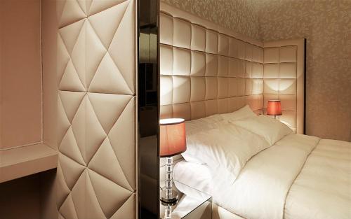 a bedroom with a white bed and two lamps at LE RÊVE DE NAIM Roma in Rome