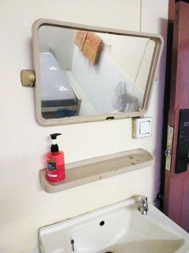 a bathroom with a mirror and a sink at Jade Crown in Yangon