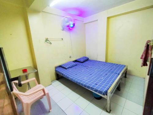 a bedroom with a blue bed and a pink ceiling at Jade Crown in Yangon