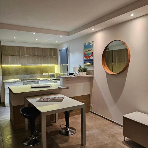 une grande cuisine avec une table et un miroir dans l'établissement Appartement les pieds dans l'eau avec terrasse et jardin, à Bandol