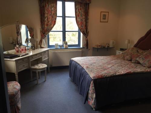 a bedroom with a bed and a sink and a window at Kingswood Cottage in Lyndhurst