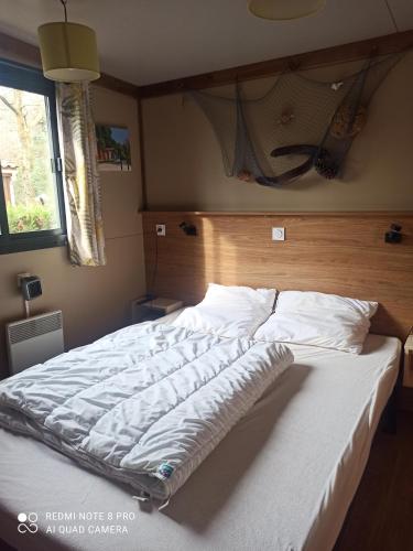 Un dormitorio con una cama grande con cabecero de madera. en Chalet RUISSEAU 02, en La Teste-de-Buch