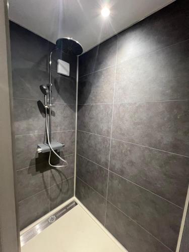 La salle de bains est pourvue d'une douche et d'un mur en carrelage. dans l'établissement Chambre d'hôtes Le Bol d'Air avec jacuzzi, à Castelnau-sur-lʼAuvignon