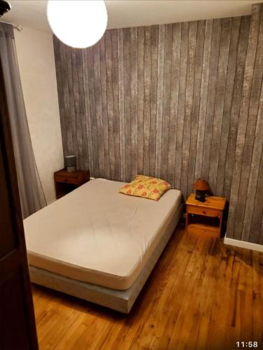 - une chambre avec un lit dans un dortoir doté de parquet dans l'établissement Maison 6 couchages, à Bellevesvre