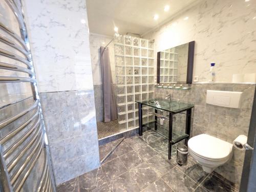 a bathroom with a toilet and a glass table at Chateau de Quesmy in Quesmy