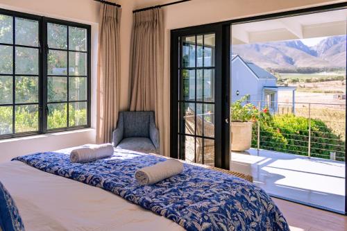 a bedroom with a bed and a large window at Klein River Cottage, Stanford Getaway in Stanford