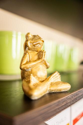 a gold figurine of a dog sitting on a shelf at Hotel Aulmann in Trier
