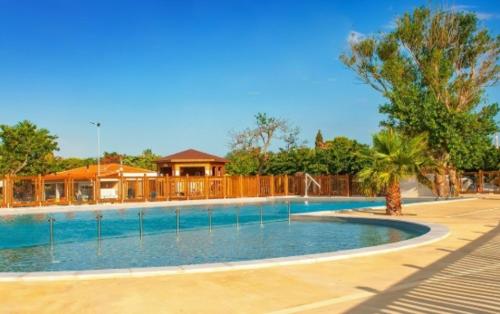 une grande piscine devant une maison dans l'établissement MOBIL HOME COSY, Plage & Piscine Chauffée, à Port-la-Nouvelle
