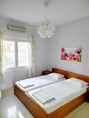 two beds in a room with two windows at Hotel Europa - Family and Senior Friendly in Kavala