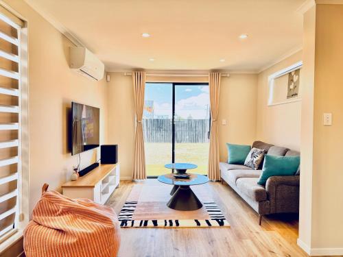 a living room with a couch and a tv at Lovely home, 3 bedrooms 4 beds, Close to hospital in Hamilton