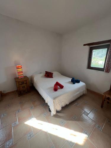 a bedroom with a bed with two red pillows on it at Cortijo Los Maximos in Turón