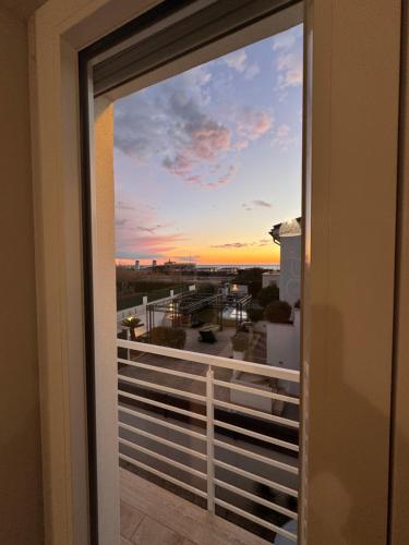 a window view of a sunset from a balcony at La Casa Vista Mare in Fregene