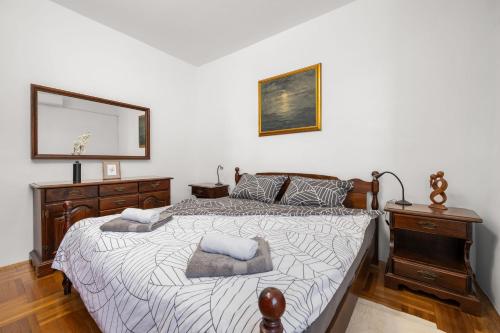 a bedroom with a bed with a mirror and a dresser at Blue Horizon Apartment a Seaside Escape in Rabac in Rabac