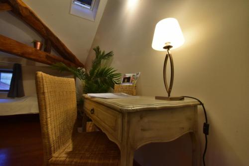 a table with a lamp on it in a room at Chambre d'hôtes L'altitude - Domaine la Rose des vents in Castelnau-sur-lʼAuvignon