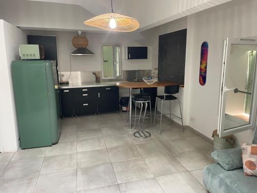 een keuken met een koelkast en een tafel. bij Appartement chaleureux climatisé in La Ciotat