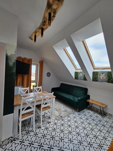 a living room with a green couch and a table at Dom Gościnny Przy Szlaku Jeleni in Ustroń