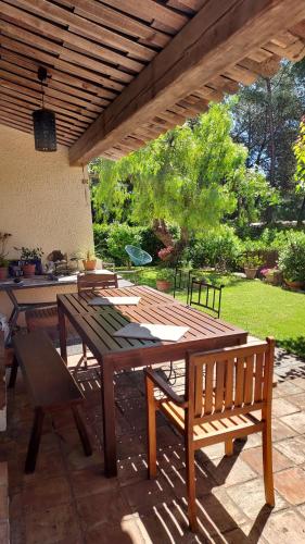 une table en bois et des bancs sur une terrasse dans l'établissement Jolie maison hauteur d'Antibes, à Antibes