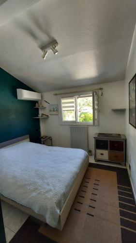une chambre avec un grand lit et une fenêtre dans l'établissement Jolie maison hauteur d'Antibes, à Antibes