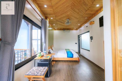 a room with a bed and a desk and a window at Asahi Villa Tam Coc in Ninh Binh