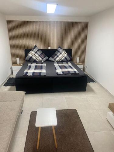 a bedroom with a black bed and a white stool at Appartment Kuschelecke in Kiefersfelden