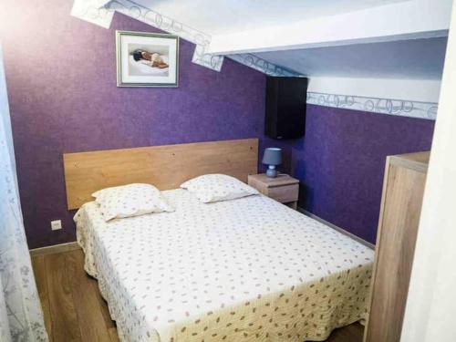 - une chambre avec un lit et un mur violet dans l'établissement Résidence Sofia Lynda, au Plan-de-la-Tour