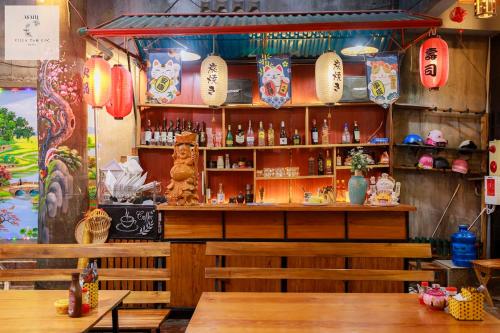 a restaurant with a bar with wooden tables and chairs at Asahi Villa Tam Coc in Ninh Binh