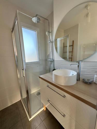 une salle de bain avec un lavabo et une douche avec un miroir dans l'établissement Maison neuve & lumineuse avec jardin, à Saint-Malo
