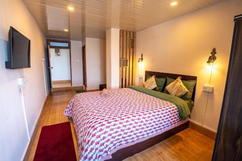 a bedroom with a bed and a television in it at Monratino Himadrie -2 mins walk from Mall Road - All rooms have Kanchenjunga Mountain View in Darjeeling