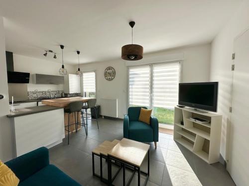 un salon avec une cuisine et un salon avec un canapé dans l'établissement Maison neuve & lumineuse avec jardin, à Saint-Malo