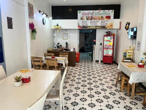 a restaurant with tables and chairs and a kitchen at The New Normal House in Chiang Mai