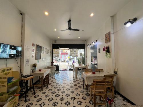 a restaurant with tables and chairs in a room at The New Normal House in Chiang Mai