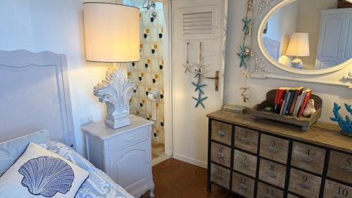 ポルトフェッラーイオにあるLa Cartomante di Bonaparteのベッドとドレッサーと鏡のある寝室
