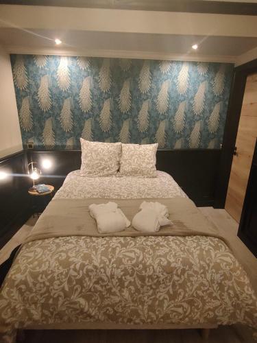 a bedroom with a large bed with two pillows at obonheurdu paon in Arques
