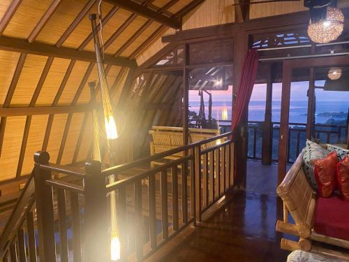 a room with a balcony with a view of the ocean at Villa Umbrella Lombok in Senggigi 