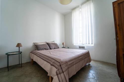 une chambre avec un grand lit avec une fenêtre dans l'établissement La Provence centre ville, piscine, jardin, terrasse, à Nîmes