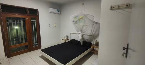 ein kleines Bett in einem Zimmer mit Fenster in der Unterkunft Maison Kemmiu Kinshasa in Kinshasa