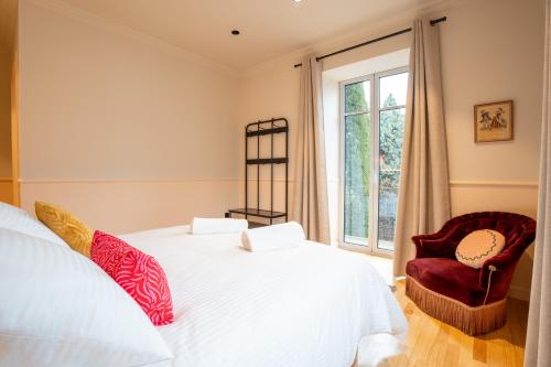 a bedroom with a bed and a chair and a window at Le Falcoz in Saint-Jean-de-Maurienne