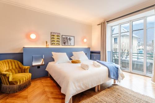 a bedroom with a large bed and a chair at Le Falcoz in Saint-Jean-de-Maurienne
