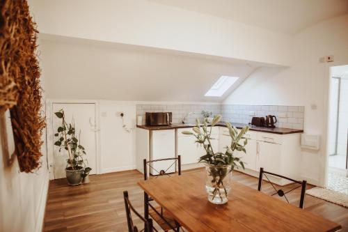 a kitchen and dining room with a wooden table at Holmfirth converted bank- centre of Town - Austen- Archive in Huddersfield