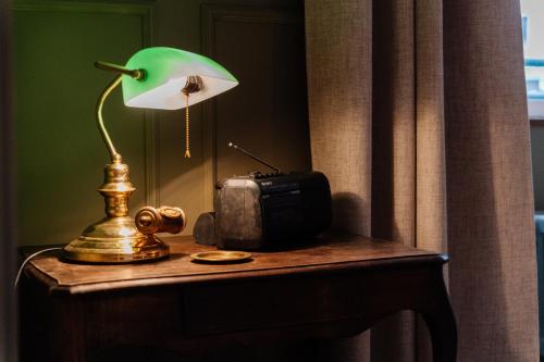 a table with a lamp and a camera on a table at Le Falcoz in Saint-Jean-de-Maurienne