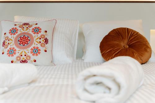 a bed with white sheets and pillows with a towel at Le Falcoz in Saint-Jean-de-Maurienne