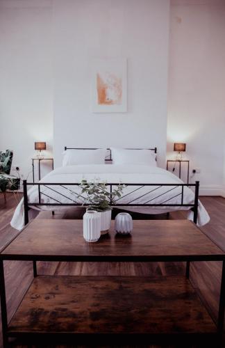 a bedroom with a bed and a wooden coffee table at Holmfirth converted bank- centre of Town - Austen- Archive in Huddersfield