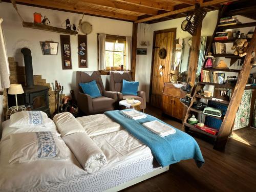 a bedroom with a large bed and a living room at Domek przy Azylu Bocianim in Hutna Wieś